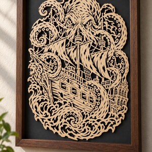 May include: A framed wall art piece featuring a light-colored, laser-cut wooden relief of a large octopus with tentacles wrapped around a sailing ship on a dark background. The intricate design shows the creature emerging from waves.