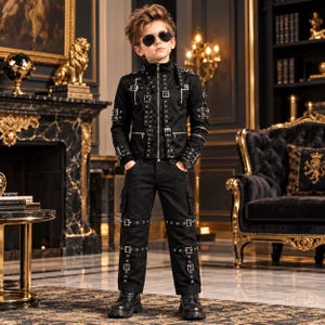 May include: A black jacket and matching trousers set featuring numerous silver-toned metal buckles, straps, and eyelets across the chest, sleeves, and legs. The jacket has a high collar and a central zipper, while the trousers include cargo-style pockets.
