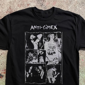 Könnte beinhalten: Ein schwarzes Kurzarm-T-Shirt mit einem weißen Grafikdruck auf der Brust. Der Druck enthält den Text "ANTI-CIMEX" oben und "ATTACK" unten, umgeben von einer Collage aus schwarz-weißen Fotografien, die Bandmitglieder darstellen.