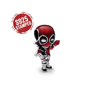 May include: A small, stylised charm featuring a character with a red and black textured suit, white eye patches, and silver accents. A red circular stamp in the upper left corner displays the white text S925 STAMPED, indicating the metal quality.
