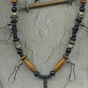 May include: An Echo Canyon lanyard with a black cord, wooden beads, and metal clasps. The lanyard includes a wine cork, fishing flies, and the text "Echo Canyon Lanyard". A tag provides details about the product.