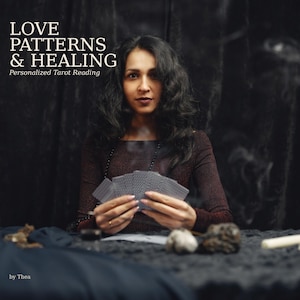 Könnte beinhalten: Eine Person mit dunklem, welligem Haar in einem dunklen Langarmshirt hält einen Fächer aus Tarotkarten. Der Text lautet LOVE PATTERNS & HEALING Personalized Tarot Reading by Thea. Dunkle Steine und eine weiße Kerze liegen auf der dunklen Fläche.