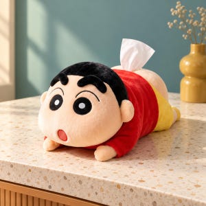 Può includere: Un copriscatola per fazzoletti in peluche a forma di personaggio dei cartoni animati con capelli neri, maglietta rossa a maniche lunghe e pantaloncini gialli. Il personaggio è sdraiato a pancia in giù con un fazzoletto bianco che spunta.