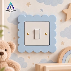 Peut inclure: Une plaque d'interrupteur bleu clair avec un bord festonné entourant un interrupteur rectangulaire blanc standard. L'interrupteur présente un bouton central vertical et deux petites vis de couleur dorée sur les côtés gauche et droit.
