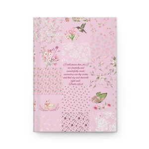 May include: A rectangular journal with a light pink cover featuring a patchwork design of various floral patterns, a hummingbird, a swan, and a butterfly. The center text reads: I will praise thee; for I am fearfully and wonderfully made: marvelous are thy works; and that my soul knoweth right well. Psalm 139:14.