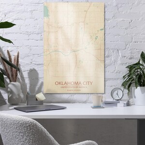May include: A vertical rectangular wall art print featuring a stylized map of Oklahoma City, United States of America. The map displays a grid of streets and roads in tan and brown tones with light blue water features, labeled with the city name.