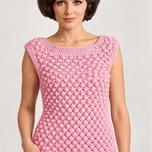 May include: A sleeveless, light pink knit top featuring a textured bobble stitch pattern throughout the body. The garment has a wide, rounded neckline and a straight hem, constructed with a consistent yarn weight and uniform stitch density.