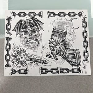 May include: A black and white ink illustration featuring a horned skull wearing a winged helmet, a spiked mace, and a gauntlet holding a chalice with bubbling liquid. The entire composition is framed by a border of heavy metal chains.