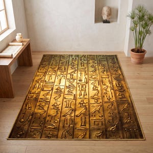 Könnte beinhalten: Ein rechteckiger Teppich mit einem metallisch goldenen und dunkelbraunen Finish, der ein wiederkehrendes Muster aus vertikalen Spalten zeigt, die mit verschiedenen ägyptischen Hieroglyphen wie Vögeln, menschlichen Figuren und geometrischen Formen im Reliefstil gefüllt sind.