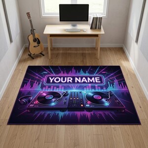 Peut inclure: Un tapis rectangulaire représentant une console de DJ avec deux platines vinyles noires et une table de mixage centrale. Le motif présente un graphique d'ondes sonores néon aux tons violets et bleus, avec un encadré affichant YOUR NAME.