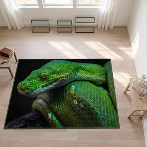 Può includere: Un tappeto rettangolare con una stampa fotografica ad alta risoluzione di un boa smeraldino verde brillante avvolto attorno a un ramo scuro. Il serpente mostra squame dettagliate, una forma della testa distinta e un occhio concentrato su sfondo nero.