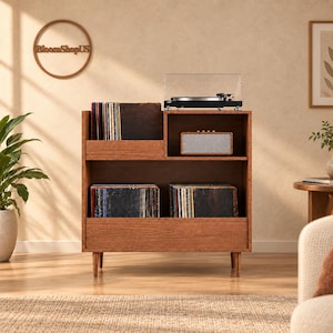 May include: A brown wooden record storage cabinet with four tapered legs, featuring an open top shelf with a turntable and speaker, and two lower compartments filled with vinyl records. The cabinet has a rectangular frame and wood grain finish.
