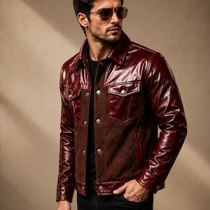 May include: A jacket featuring a combination of glossy dark red leather panels on the sleeves, collar, and chest pockets, contrasted with a matte dark brown quilted suede torso. The garment includes silver-toned metal snap buttons down the front.