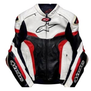 Könnte beinhalten: Eine Motorradjacke aus weißem, schwarzem und rotem Leder mit dem Alpinestars-Logo auf Brust, Kragen und Ärmeln. Die Jacke verfügt über einen durchgehenden Frontreißverschluss, einen Stehkragen mit Druckknopfverschluss und perforierte Ledereinsätze.