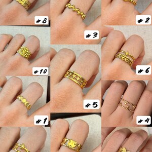 May include: A collection of eleven gold-toned rings displayed on fingers, featuring various designs including leaf patterns, star motifs, heart shapes, moon symbols, beaded textures, and openwork bands, each labelled with a corresponding number from one to eleven.