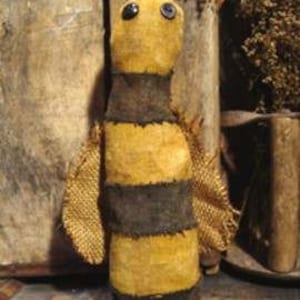 May include: A handmade felt bee with black and yellow stripes, brown wings, and black button eyes.