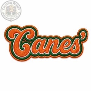 Puede incluir: Un parche bordado que muestra la palabra Canes en una fuente cursiva. Las letras son de color naranja con un contorno blanco y un borde verde oscuro. El parche tiene un borde festoneado que sigue el contorno del texto, creando un efecto.