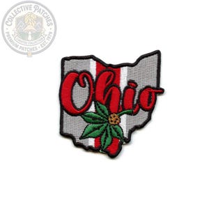 May include: An embroidered patch shaped like the state of Ohio, featuring a gray and red vertical striped background. The word Ohio is stitched in red cursive script across the center, with a green buckeye leaf and brown nut layered over it.