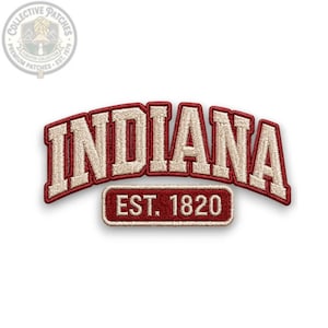 May include: An embroidered patch featuring the word INDIANA in a large, arched, cream-colored font with a dark red border. Below the word, a rectangular patch displays the text EST. 1820 in a matching cream font on a dark red background.