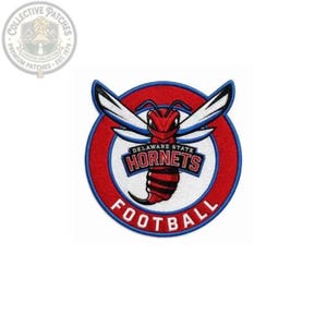 May include: A circular embroidered patch featuring a red hornet mascot with white wings centred on a red background with a blue border. The text DELAWARE STATE HORNETS is printed in blue and red, with the word FOOTBALL in white at the bottom.