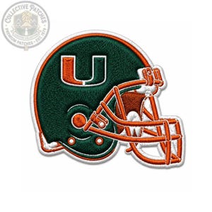 May include: An embroidered patch shaped like a football helmet in dark green and orange. The helmet features a prominent orange letter U on the side and an orange face mask. The entire design is outlined in white thread against a plain background.
