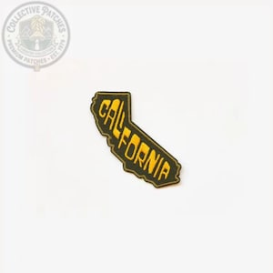 May include: An embroidered patch in the shape of the state of California. The patch features a dark olive green background with the word CALIFORNIA stitched in bold, yellow, sans-serif capital letters running diagonally across the center.