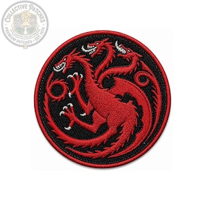 Op de afbeelding: Een ronde geborduurde patch met een ontwerp van een rode draak met drie koppen op een zwarte achtergrond. De draak heeft scherpe witte tanden en klauwen, met een lange staart die langs de rand krult. De patch heeft een dikke rode stikrand.