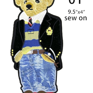 May include: An embroidered sew-on patch of a teddy bear wearing a black blazer, a blue and yellow striped sweater, a white collared shirt with a tie, and blue jeans. The patch measures 9.5 inches by 4 inches and is labeled with the number 01.