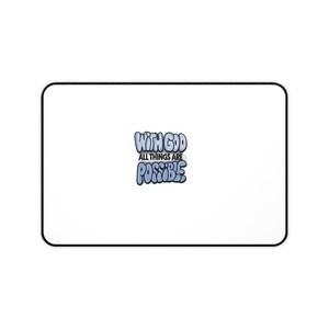 May include: A rectangular desk mat with a white surface and a black border. Centered on the mat is a graphic with the text "WITH GOD ALL THINGS ARE POSSIBLE" written in a stylized, bubble-letter font with light blue and dark blue shading.