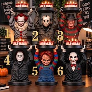 Puede incluir: Seis bustos de personajes de películas de terror, cada uno sosteniendo una bandeja negra redonda con un pequeño pastel con glaseado blanco y gotas rojas. Los personajes incluyen a Pennywise, Jason Voorhees, Freddy Krueger, Michael Myers, Chucky y Billy.