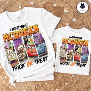 May include: Two white t-shirts featuring a graphic print with the text LIGHTNING MCQUEEN TRICK OR TREAT. The design shows four vertical panels with cartoon cars dressed in Halloween costumes, including a mummy, a vampire, and a witch hat.