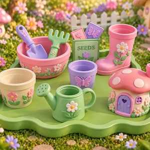 Puede incluir: Un conjunto de accesorios de jardinería en miniatura sobre una bandeja verde, que incluye un cuenco rosa con una pala morada y un rastrillo verde, una caja de semillas, una maceta con forma de bota rosa, una maceta morada, una regadera y una casa seta.