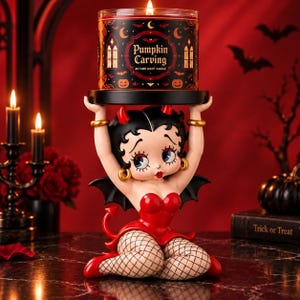 Peut inclure: Un bougeoir représentant un personnage de dessin animé déguisé en diable avec des cheveux noirs, des cornes rouges et une tenue rouge, tenant une bougie cylindrique noire étiquetée Pumpkin Carving avec des motifs d'automne et des chauves-souris.