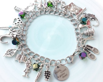 May include: Silver charm bracelet with various charms, including a leaf, book, ballet shoes, and a round charm with the text "Faith, trust & pixie dust." The bracelet also features iridescent green and purple crystal accents.