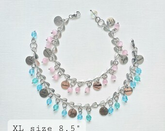 May include: Two silver-toned charm bracelets with pink and blue beads. Each bracelet has a leaf design and small round charms with words like "Joy" and "Kindness." The XL size is 8.5 inches.