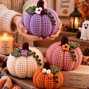 May include: Four crocheted pumpkins in lavender, cream, pink, and orange. Each pumpkin features a dark brown stem, green crocheted leaves, a curly vine, and small decorative flowers. The pumpkins are textured with a consistent stitch pattern.