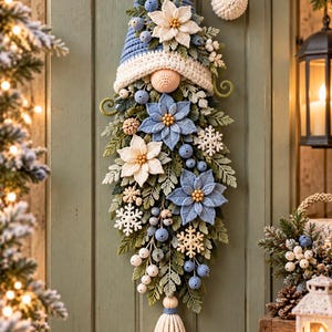 May include: A vertical crochet wall hanging shaped like a gnome, featuring a blue pointed hat with a white pom-pom, a round beige nose, and a long beard decorated with blue and white poinsettia flowers, green leaves, berries, and snowflakes.