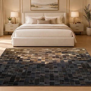 May include: A rectangular area rug featuring a patchwork design of small square tiles in a gradient color scheme. The pattern transitions from dark charcoal and black tones at the bottom to lighter shades of tan, beige, and cream at the top.