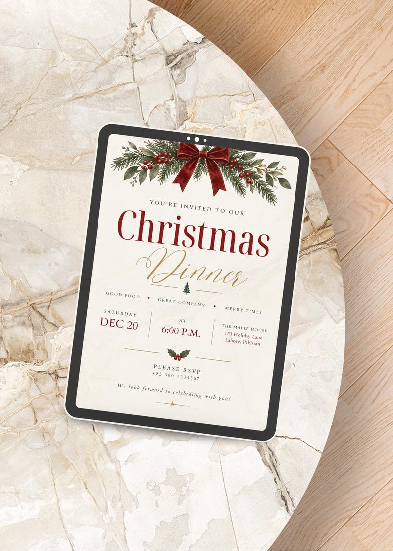 May include: A digital tablet displaying a Christmas dinner invitation with a cream background, red text, and a festive illustration of pine branches, red berries, and a dark red bow at the top. The text includes event details and RSVP information.