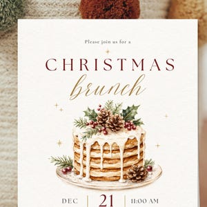 Op de afbeelding: Een rechthoekige uitnodigingskaart met de tekst Please join us for a CHRISTMAS brunch. Het ontwerp bevat een aquarelillustratie van een stapel pannenkoeken met wit glazuur, dennenappels, hulstbladeren en bessen. De datum DEC 21 en 11:00 AM staan onderaan gedrukt.