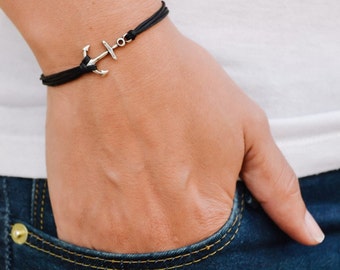 May include: A black cord bracelet with a silver anchor charm.