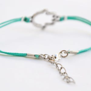 Pu&ograve; includere: Un braccialetto con cordino turchese e ciondolo a forma di mano di Hamsa argentato. Il braccialetto presenta un'estensione a catena e una chiusura delicate. La mano di Hamsa &egrave; un simbolo di protezione. Un accessorio elegante.