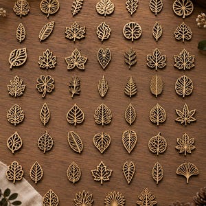Peut inclure: Une collection de cinquante-six petites découpes de feuilles en bois brun clair disposées en grille. Chaque pièce présente un design unique et complexe découpé au laser, représentant diverses formes botaniques, dont l'érable, le chêne et le ginkgo.