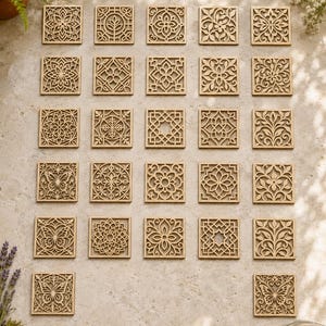 May include: A collection of twenty-six square wooden tiles featuring intricate laser-cut patterns. The designs include various geometric shapes, floral motifs, and butterfly silhouettes, all rendered in a light brown wood tone with cut-out details.