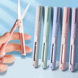 May include: A set of five portable, pen-shaped scissors in pastel colors including light gray, mint green, light blue, light pink, and lavender. Each tool features a retractable metal blade mechanism that slides out to function as scissors.