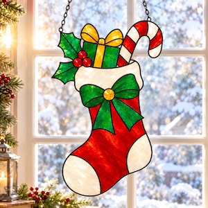 May include: A stained glass Christmas stocking suncatcher featuring a red and white stocking with a large green bow, a green gift box with a yellow bow, red holly berries, green leaves, and a red and white striped candy cane hanging by a chain.