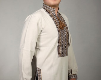 Peut inclure: Une chemise blanche à manches longues avec des broderies brunes et noires sur le devant et les poignets. La chemise a un motif ukrainien traditionnel.