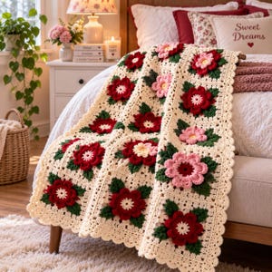 Può includere: Una coperta all'uncinetto color crema con un motivo ripetitivo di quadrati. Ogni quadrato contiene un fiore tridimensionale nelle tonalità del rosso scuro o del rosa tenue con foglie verde scuro, bordato da un bordo all'uncinetto smerlato.