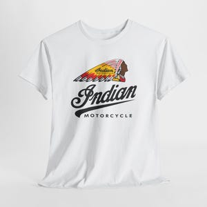 May include: A white short-sleeve t-shirt featuring a graphic of a person wearing a feathered headdress in red, yellow, and black. Below the graphic, the text reads Indian in a large script font, followed by the word MOTORCYCLE in black.