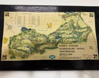 May include: A rectangular framed print featuring a detailed map of the King's Course at Gleneagles Hotel in Perthshire, Scotland. The map includes a hole-by-hole scorecard, a compass rose, a Scottish flag, and a black textured frame border.